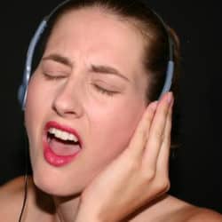 Singer train her voice with headphones on.
