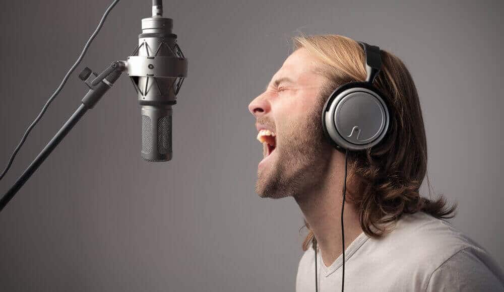 Male singer is practising to add distorted and grit voice in his singing.